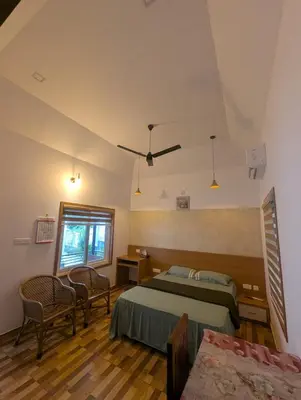 a bedroom with a bed and a table and chairs at Vayalil Homestay in Karuvārakundu