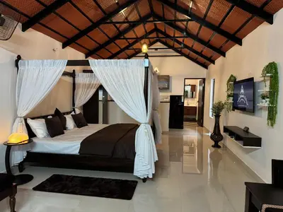 a bedroom with a bed with a canopy at Coorg Robusta Retreat in Suntikoppa