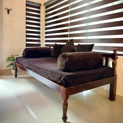 a couch sitting in a room with a window at Coorg Robusta Retreat in Suntikoppa