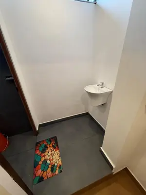 a bathroom with a sink and a painting on the floor at AAN GREENS Rooms And Dormitorys in Vaduvanchal