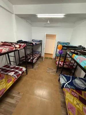 a room filled with lots of bunk beds at AAN GREENS Rooms And Dormitorys in Vaduvanchal
