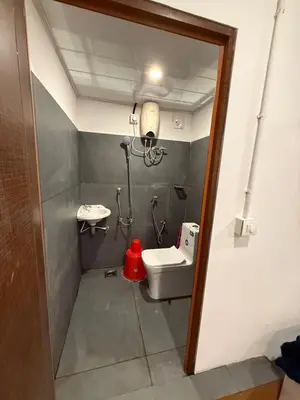 a small bathroom with a toilet and a sink at AAN GREENS Rooms And Dormitorys in Vaduvanchal