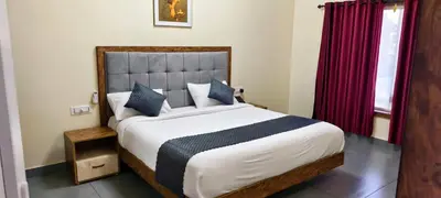 a bedroom with a large bed with blue pillows at Pakalakam Resorts in Cheruppulasseri