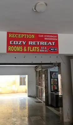 a building with a sign for rooms and flats at Cozy retreat in Mysore