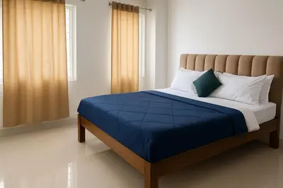 a bedroom with a bed with a blue comforter at Cozy retreat in Mysore