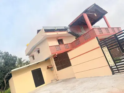 a house with a balcony on top of it at Lakshminarayanappa Niwasa in Channapatna