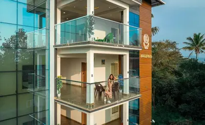 a building with a balcony with people standing on it at Boulevard Premium Luxury Hotel in Munnar