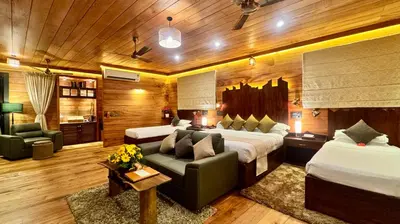 a hotel room with two beds and a couch at Tranquil Resort - Blusalzz Collection, Wayanad - Kerala in Ambalavayal