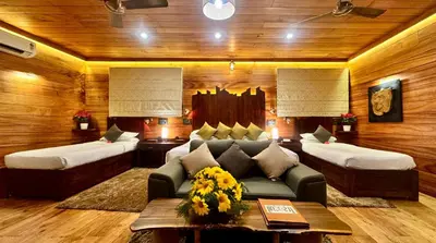a living room with two beds and a couch at Tranquil Resort - Blusalzz Collection, Wayanad - Kerala in Ambalavayal
