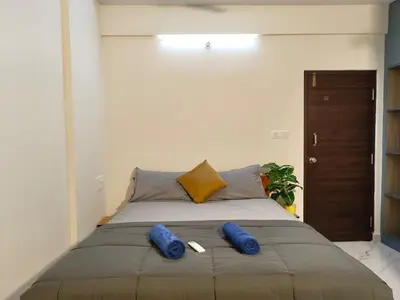 a bed with two blue pillows on top of it at Luxurious 3BHK AC, Peaceful location, Premium stay in Mysore