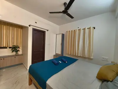 a bedroom with a large bed with a ceiling fan at Luxurious 3BHK AC, Peaceful location, Premium stay in Mysore