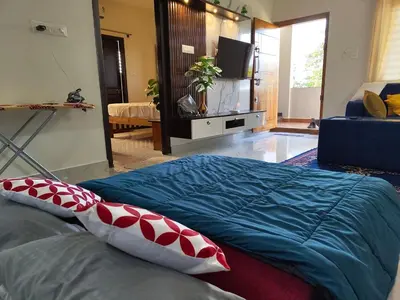a bedroom with a bed with pillows and a television at Luxurious 3BHK AC, Peaceful location, Premium stay in Mysore