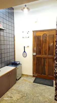 a kitchen with a wooden door in a room at JEO Home Stay And Hospitality in Mysore