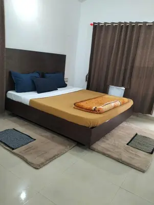 a bedroom with a large bed with blue pillows at Coorg Namana homestay in Suntikoppa