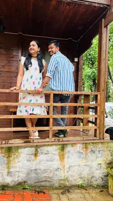 a man and a woman standing on a porch at Coorg Namana homestay in Suntikoppa