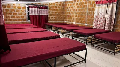 a row of red benches in a room at bandipur stay in Tāmarakarai