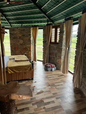 a bedroom with a bed and a stone wall at bandipur stay in Tāmarakarai