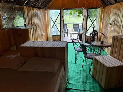a room with a bed and a table and chairs at bandipur stay in Tāmarakarai