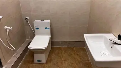 a bathroom with a toilet and a sink at bandipur stay in Tāmarakarai