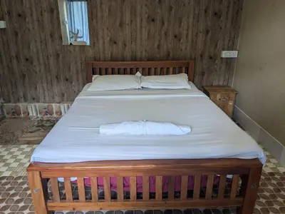 a bedroom with a bed with a towel on it at Ashokavanam Heritage Village by N Square in Kanthalloor