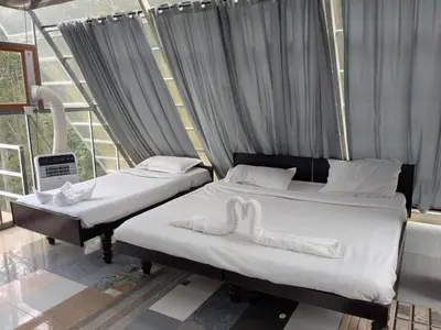 two beds in a room with two swans on them at Ashokavanam Heritage Village by N Square in Kanthalloor