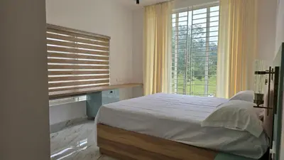 a bedroom with a bed and a large window at Casa Bella - The Group Stay in Sultan Bathery