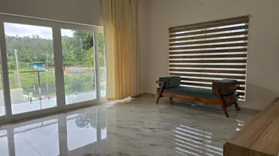 a living room with a couch and a large window at Casa Bella - The Group Stay in Sultan Bathery