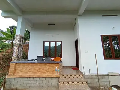 a white house with a table and chairs in it at Jungle View Homestay Anakulam in Viripara