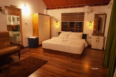 a bedroom with a large white bed and a couch at Heaven Crest Holidays and Plantations in Chithragiri