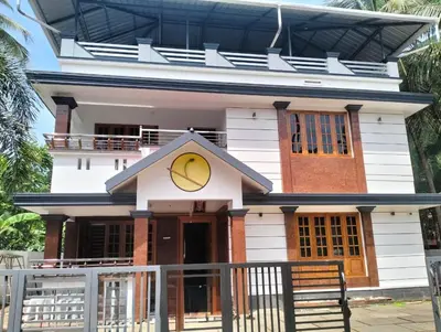 a white house with a yellow circle on it at Keshavam Homestay in Guruvāyūr