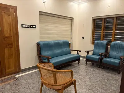 a waiting room with two blue chairs and a door at Keshavam Homestay in Guruvāyūr