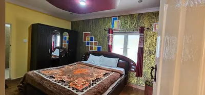 a bedroom with a bed and a window at Stay Awhile Cottages in Ooty