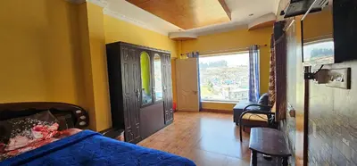 a bedroom with a bed and a window and a door at Stay Awhile Cottages in Ooty