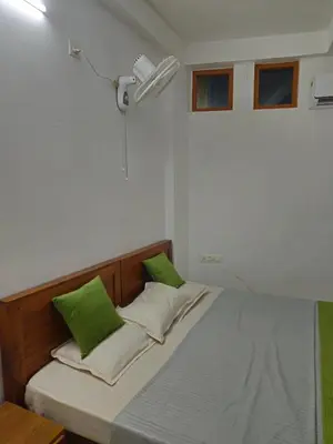 a bed with two green pillows in a room at RF Tower in Kozhikode
