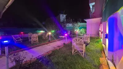 a group of chairs sitting in a yard at night at Nature View Private Villa in Ooty