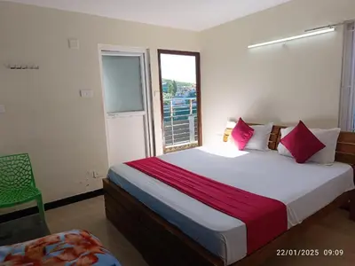 a bedroom with a large bed and a window at Queenhill Apartment in Ooty