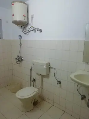 a bathroom with a toilet and a sink at Queenhill Apartment in Ooty