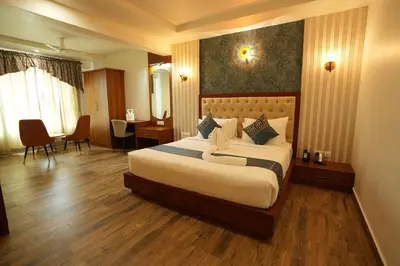 a hotel room with a bed and a dining room at Captains Crown Hotels & Resorts in Kushālnagar