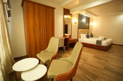 a hotel room with a bed and a table and chairs at Captains Crown Hotels & Resorts in Kushālnagar
