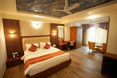 a hotel room with a large bed and a desk at Captains Crown Hotels & Resorts in Kushālnagar
