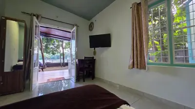 a bedroom with a bed and a window and a television at Rivulet Dale in North Paravur