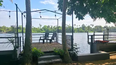 two chairs sitting on a swing by the water at Rivulet Dale in North Paravur
