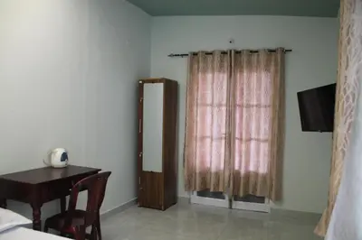 a room with a desk and a window with a table at Rivulet Dale in North Paravur