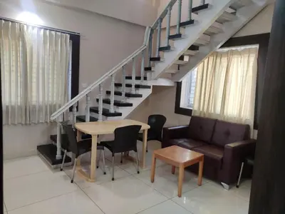 a living room with a staircase and a table and a couch at Brindavan Service Apartments in Mysore