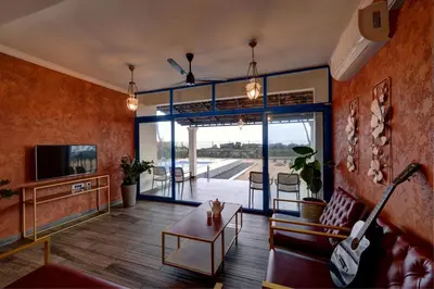 a living room with a couch a table and a tv at Bougainvillea Beach Home - Guruvayur - Chavakkad in Manattala