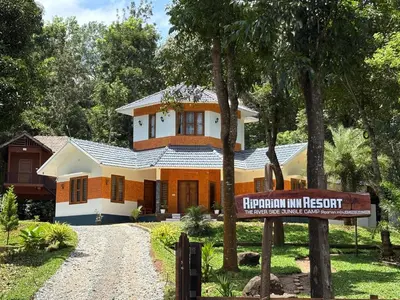a house with a sign in front of it at Riparian Inn Resort in Chekadi
