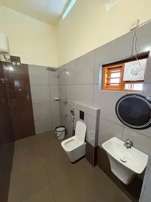 a bathroom with a toilet and a sink at Riparian Inn Resort in Chekadi