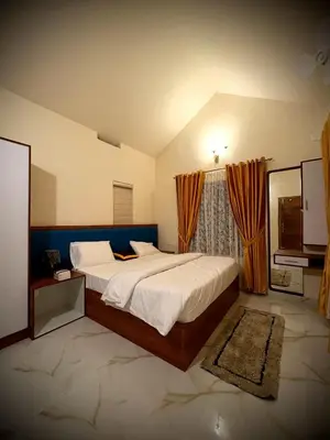 a bedroom with a large bed and a television at Riparian Inn Resort in Chekadi