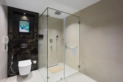 a bathroom with a glass shower with a toilet at Fortune Airport Road Kochi - Member ITC hotels' group in Cochin