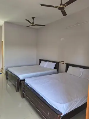 two beds sitting next to each other in a bedroom at APM Lodge in Palaiya Ayakkudi
